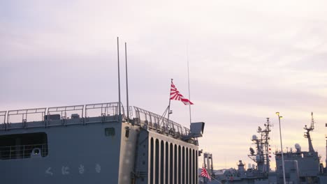 japanese naval ensign flag flying on maritime self defense force ship, kure city