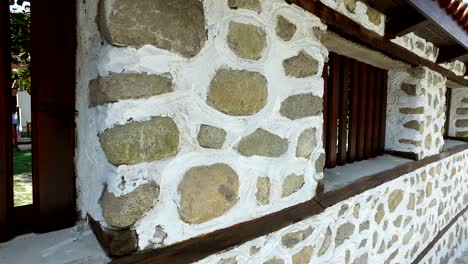 walking along stone wall with ancient windows, 4k steadicam pov