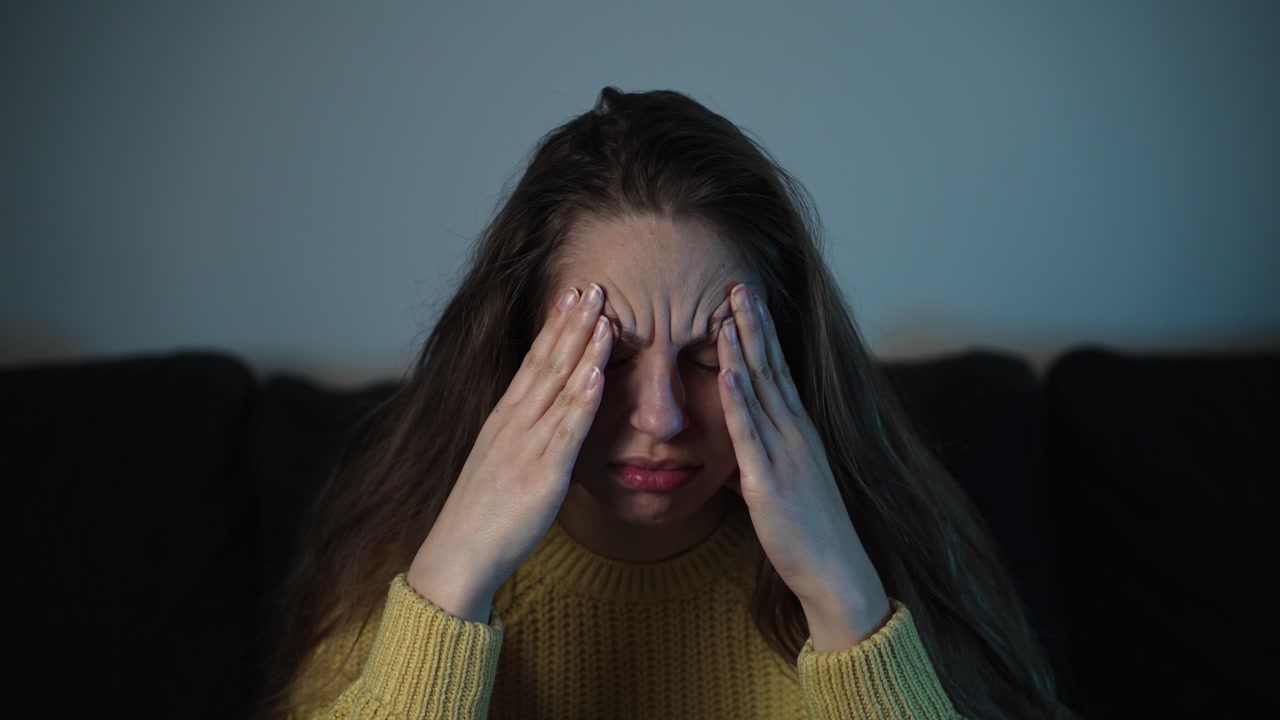 Sick female coughing on couch at home. Concept of seasonal flu, virus spread, cold weather illness, and personal healthcare.