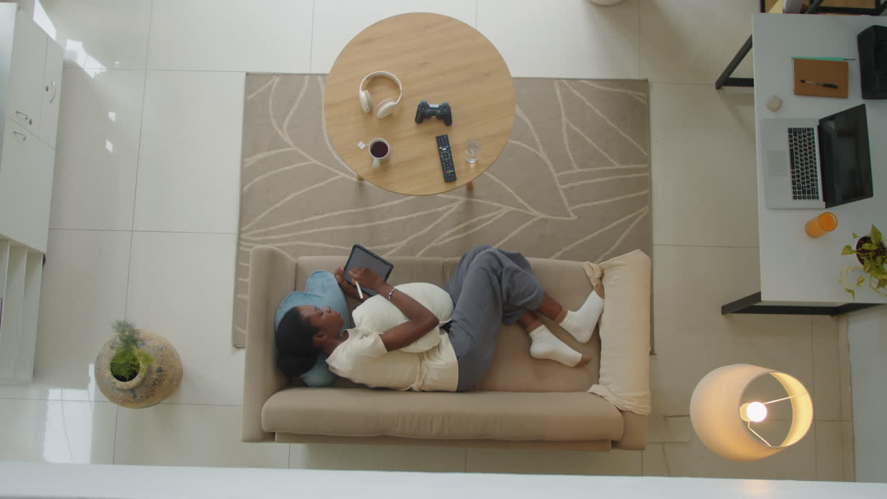 Gen Z Woman Using Tablet PC when Lying on Couch