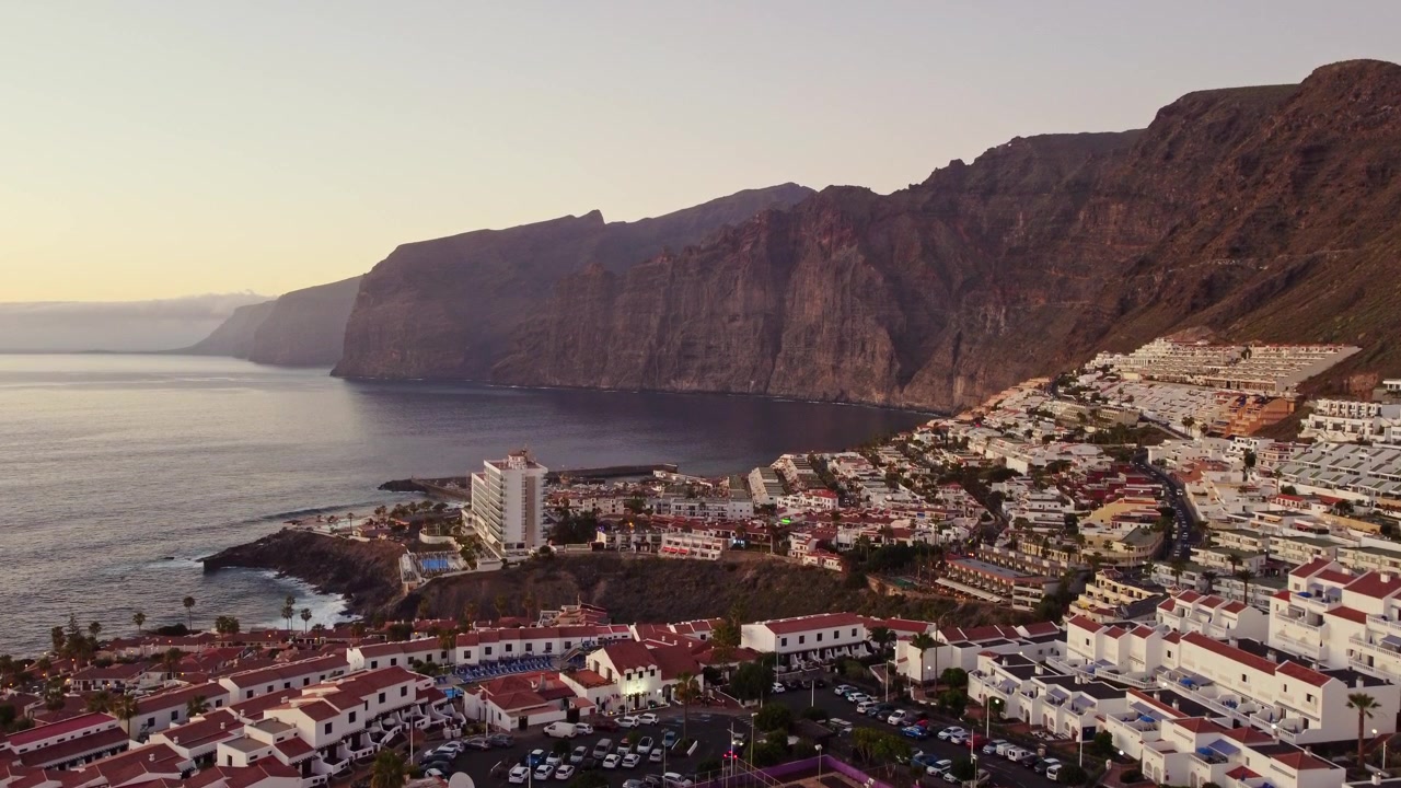 Vista aérea de la costa y zona turística de Puerto Santiago y la bahía de Los Gigantes, Tenerife, Islas Canarias. Grabación con dron que muestra el hotel TUI BLUE Los Gigantes y los acantilados rocosos del Valle de Masca.