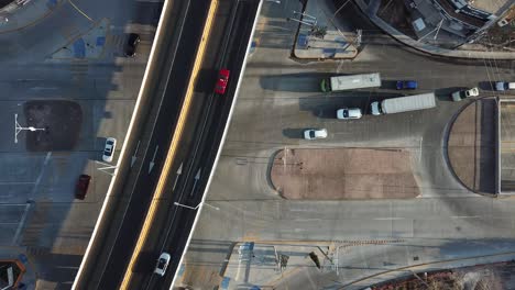 overhead aerial of busy urban city road traffic under an overpass bridge