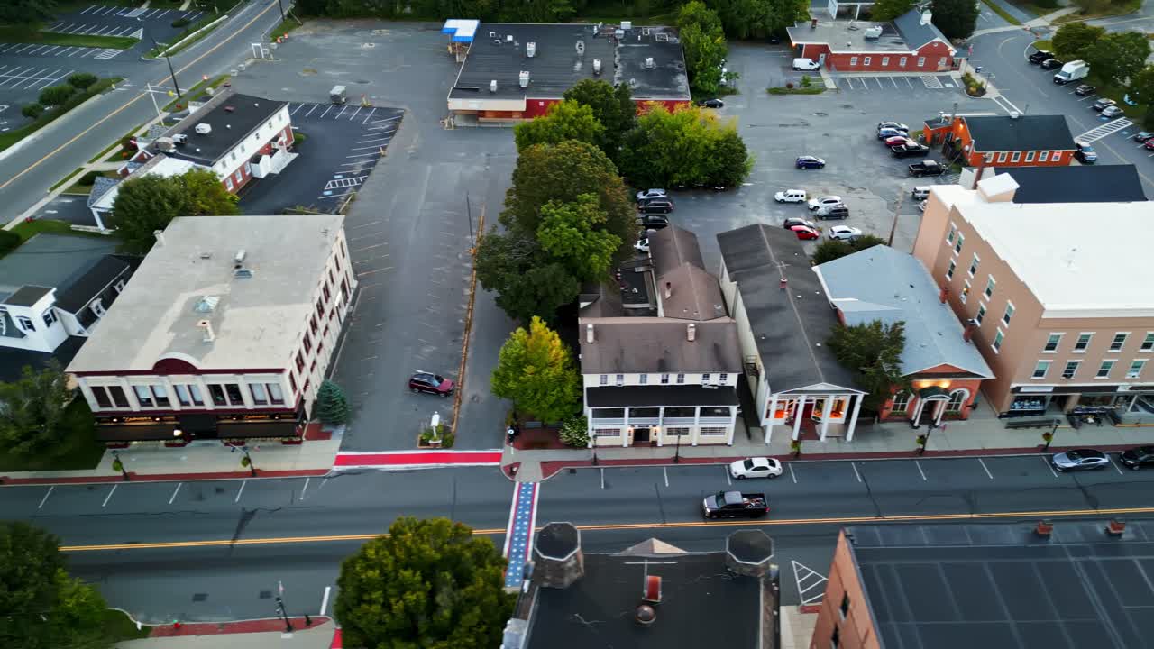 Driving Pickup Truck on Main Street of historic small american town in autumn season. Ancient colored facade of buildings in center of Lee Town, Massachusetts, USA. Aerial tracking top down