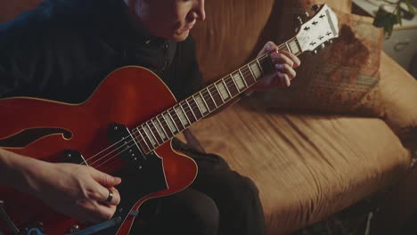 man playing an electric guitar on a couch
