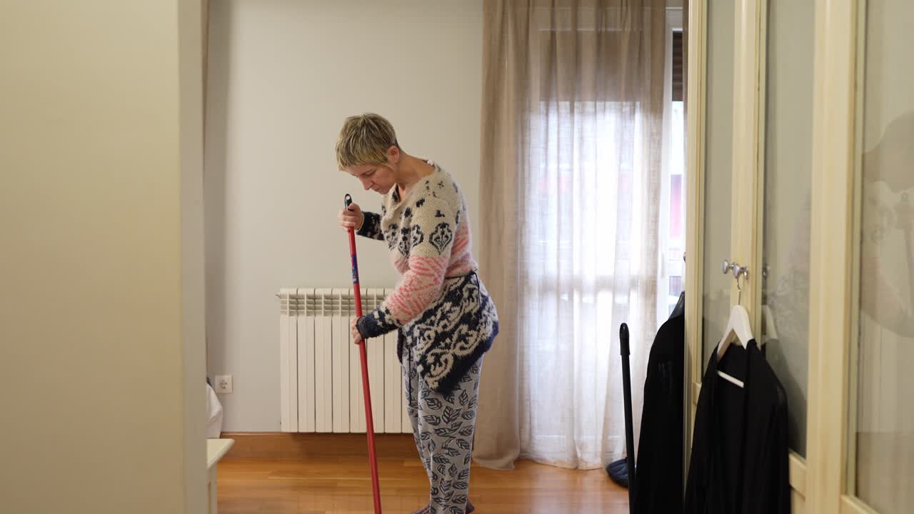 Una donna che pulisce una camera da letto