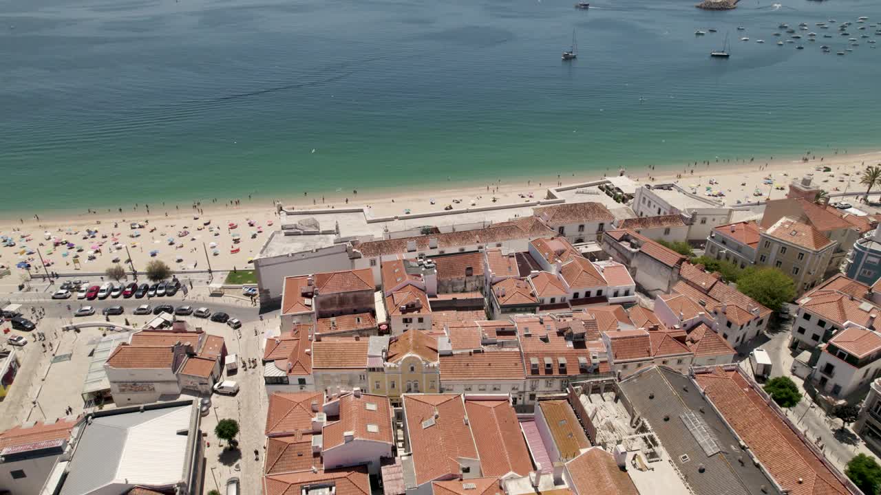 Ripresa aerea all'indietro di una meravigliosa spiaggia e del villaggio retrostante.
