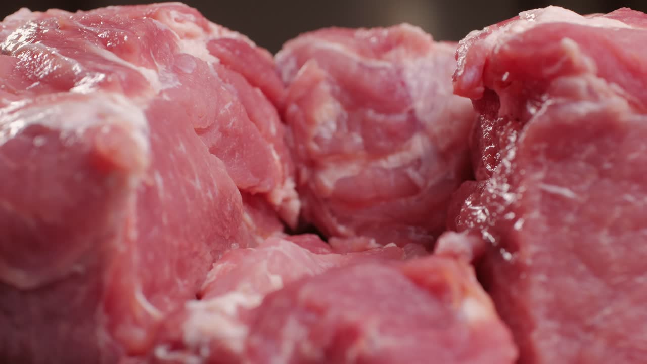 Chef Butcher cutting pork meat with knife on kitchen, cooking Mexican traditional food. Man cut big beef piece for barbecue bbq.