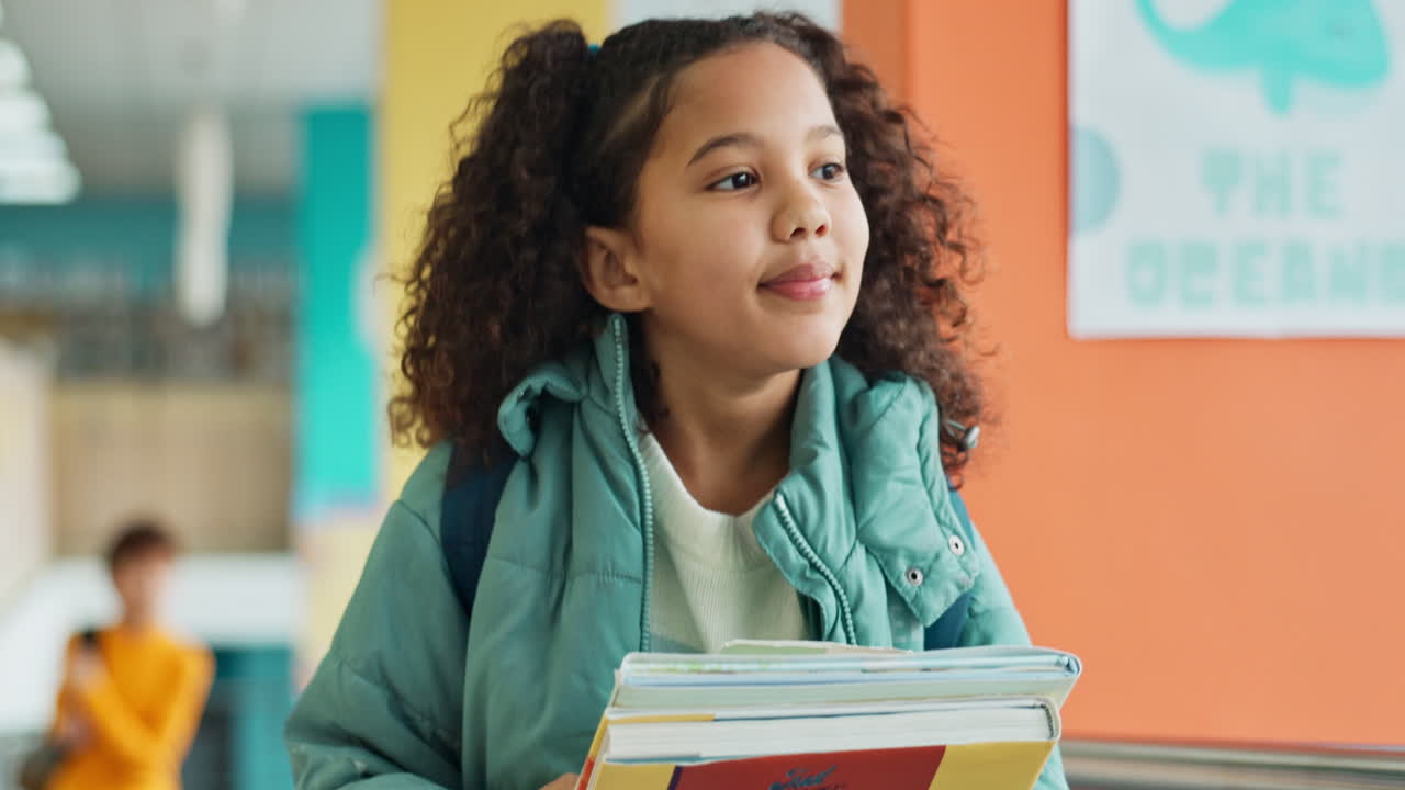 Ragazza con libri nel corridoio della scuola