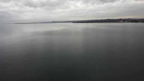 Aerial-view-of-Lake-Constance,-a-happy-cloudy-autumn-day,-in-the-background-the-country-of-Germany-with-the-hills-and-forest-to-the-shores,-Bregenz,-Vorarlberg,-Austria,-Europe