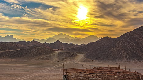 Clouds-roll-above-majestic-desert-mountains-during-bright-sunset,-fusion-time-lapse