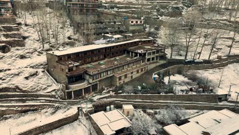 reveal orbital drone shot of the wooden house in the mountain of karimabad hunza in northern pakistan