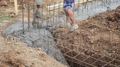 wet concrete pours into reinforced rebar foundation trench new house build