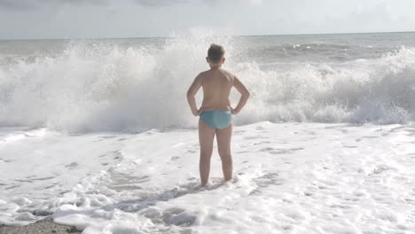 boy watching waves on the beach