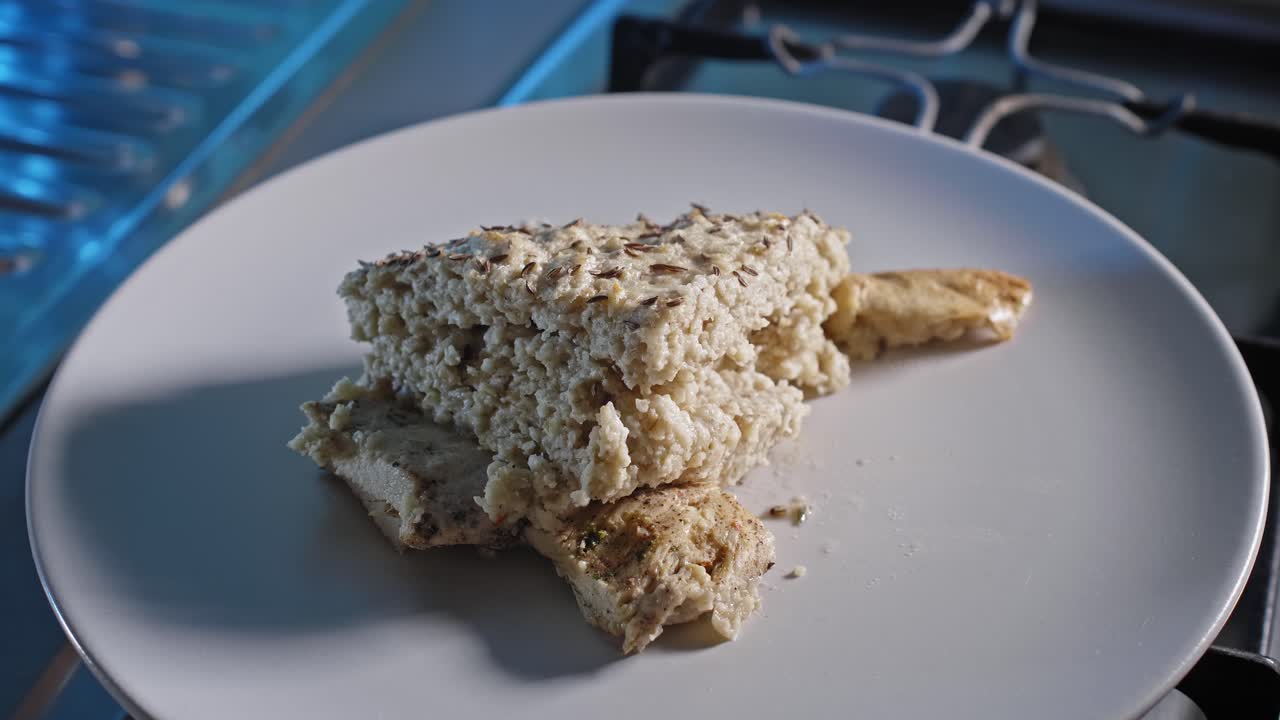 Porzione di avena al forno e pollo in un piatto.