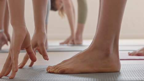 zbliżenie stóp kobiety na zajęciach jogi rozciągające się, ćwiczące pozę zgięcia do przodu, cieszące się treningiem w studiu fitness