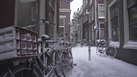 bicycles covered in heavy winter snow, leiden city streets in netherlands