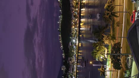 Timelapse-Vertical-Nocturno-Al-Atardecer-Del-Tráfico-De-Noumea,-Vida-Nocturna-Alrededor-De-La-Bahía-De-Orphelinat