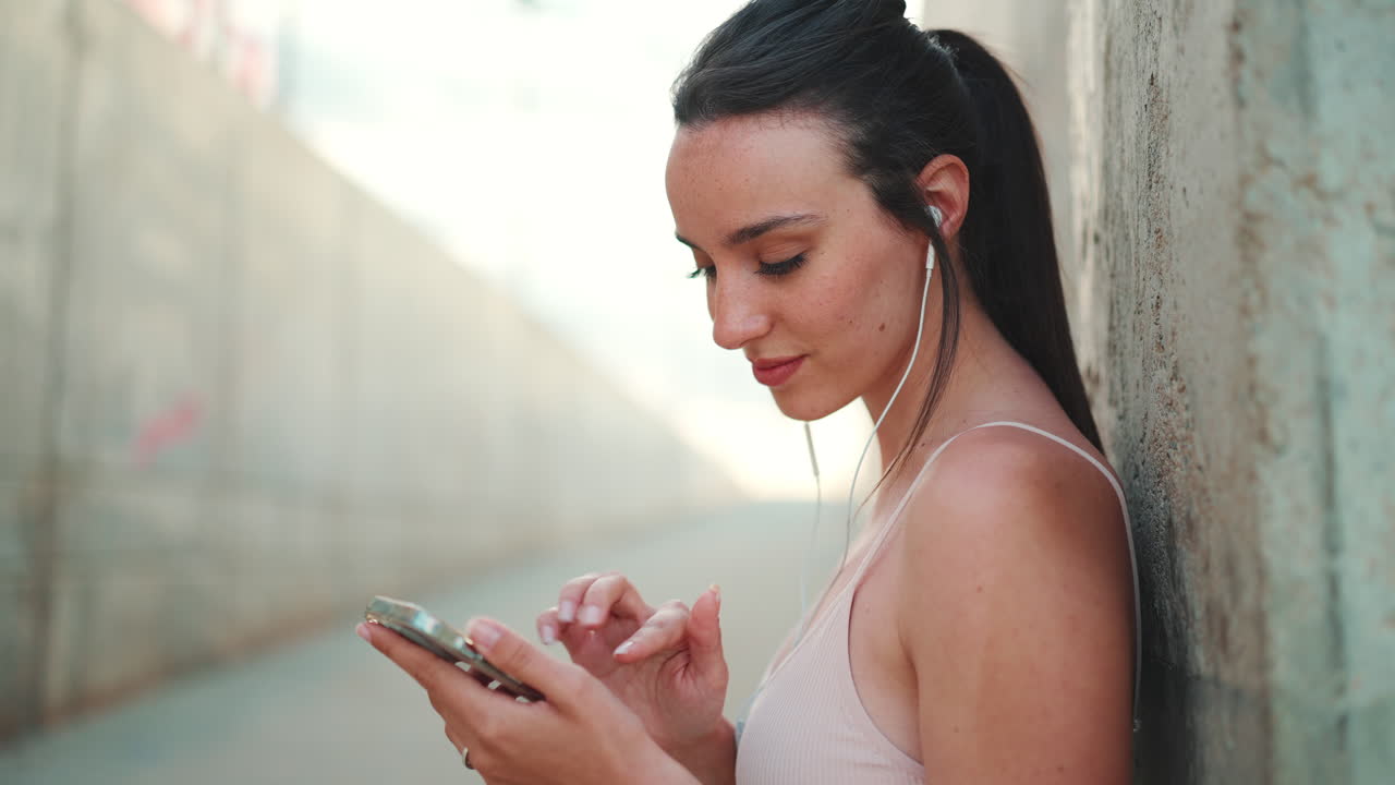 Woman with earphones using smartphone