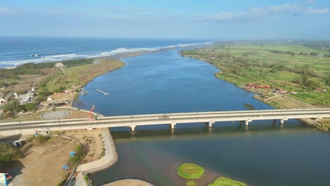 circular drone shot shows the landscape with kretek 2 bridge and the ocean near depok beach, indonesia