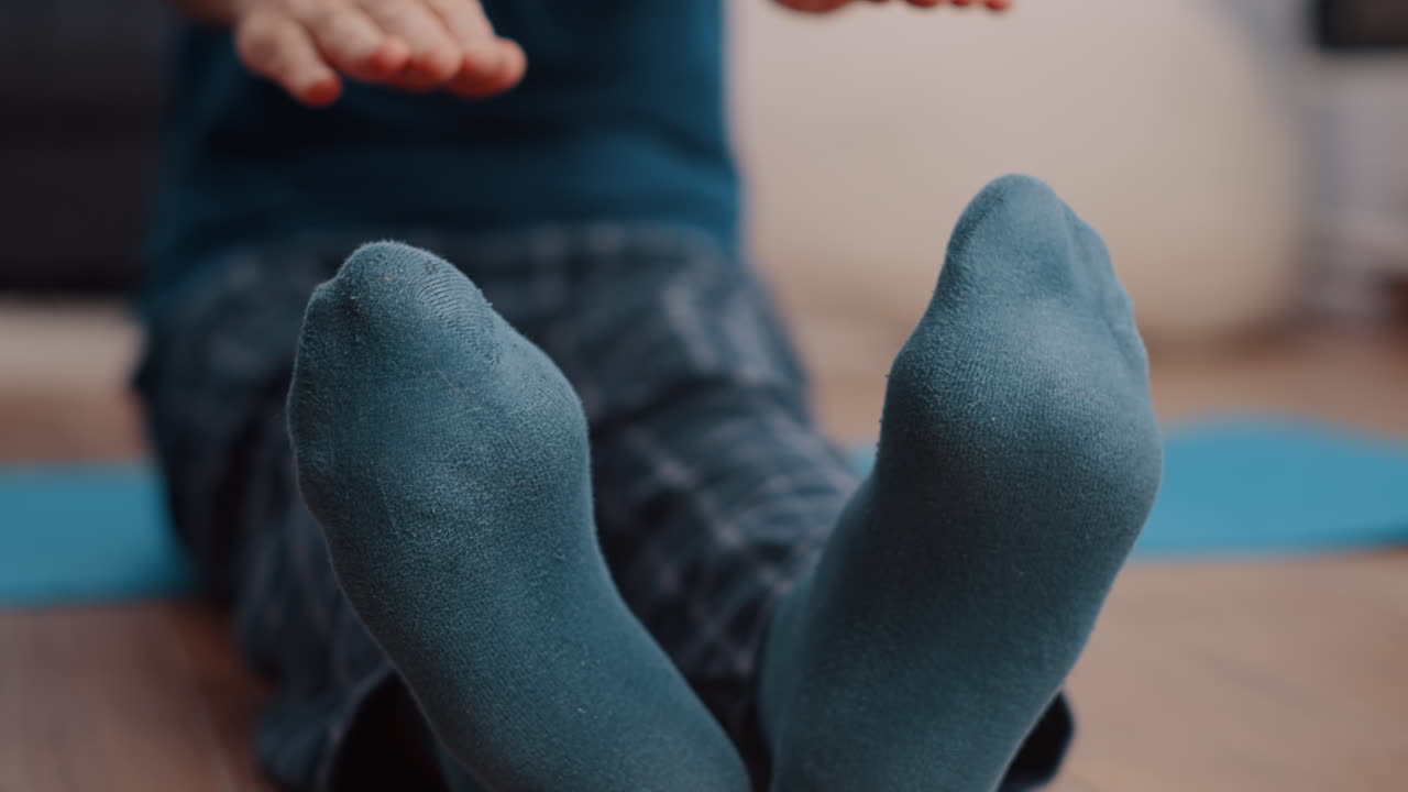 Close up of man stretching arms and legs muscles on yoga mat