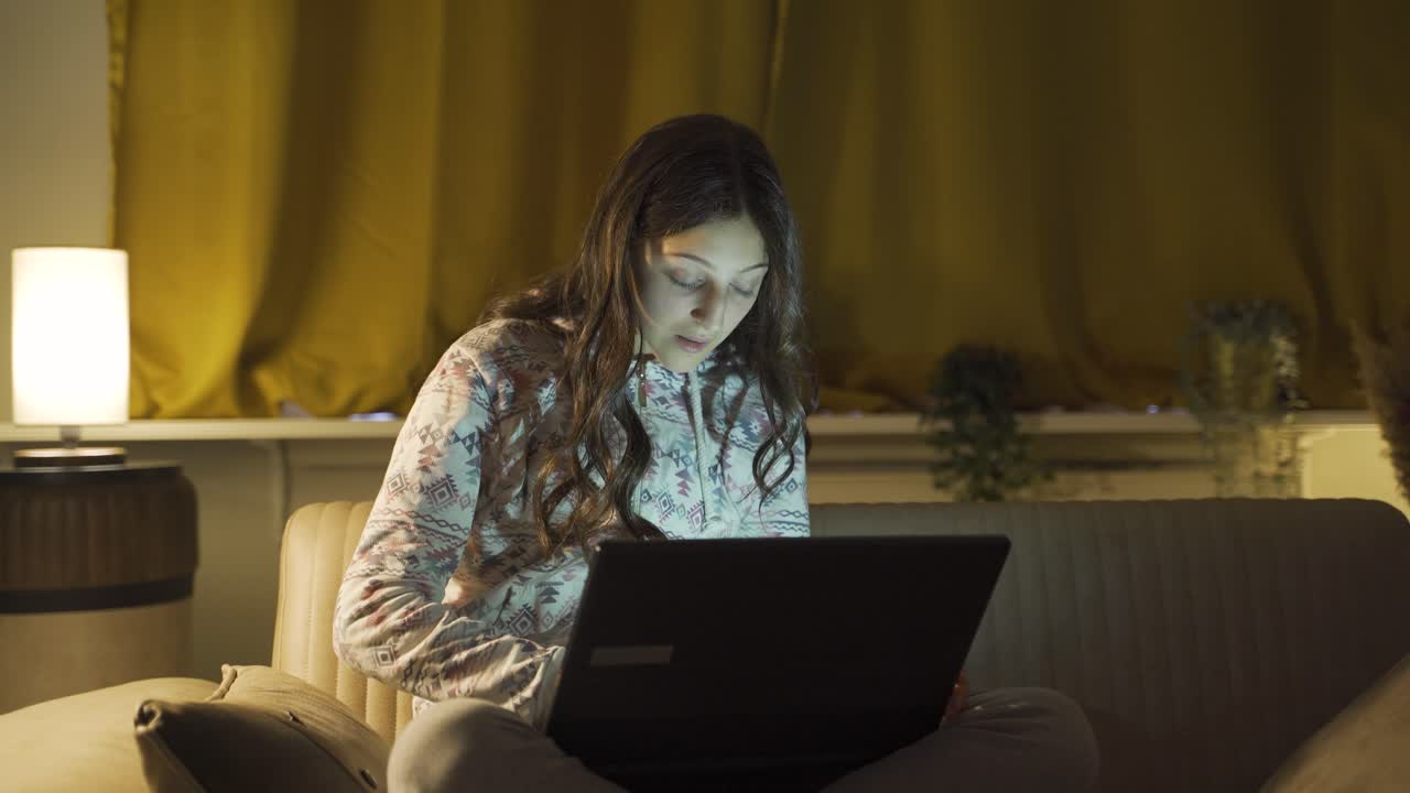 mujer joven mirando la computadora portátil con sorpresa por la noche en casa. sorprendido por lo que vio en la computadora portátil.
