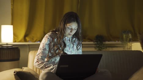 Mujer-Joven-Mirando-Una-Computadora-Portátil-Sorprendida-Por-La-Noche-En-Casa.-Sorprendido-Por-Lo-Que-Vio-En-La-Computadora-Portátil.