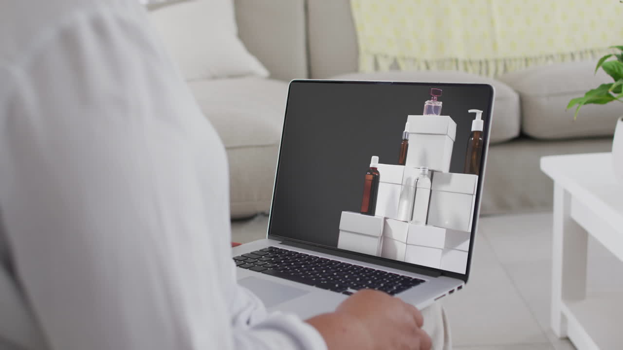 donna biraciale che usa un portatile a casa per fare acquisti online, in rallentatore