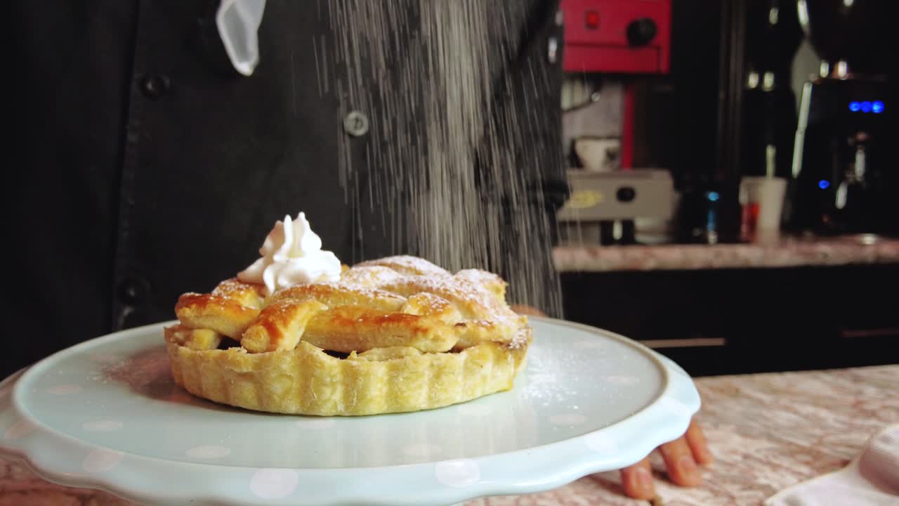 멕시코 라틴 아메리카의 카페테리아 커피숍 레스토랑에서 사과 파이 슈트루델에 라틴 남성 바리스타가 가루 설탕을 뿌리고 있습니다.