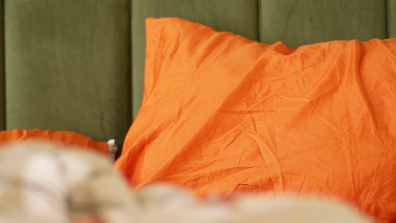 Orange Pillow on a Bed