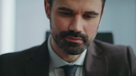 el jefe guapo escribiendo mensajes de texto en el teléfono inteligente en la oficina de cerca. mensajería de hombre de negocios
