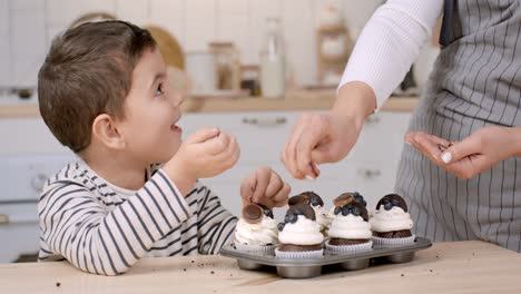 child and mother baking cupcakes together