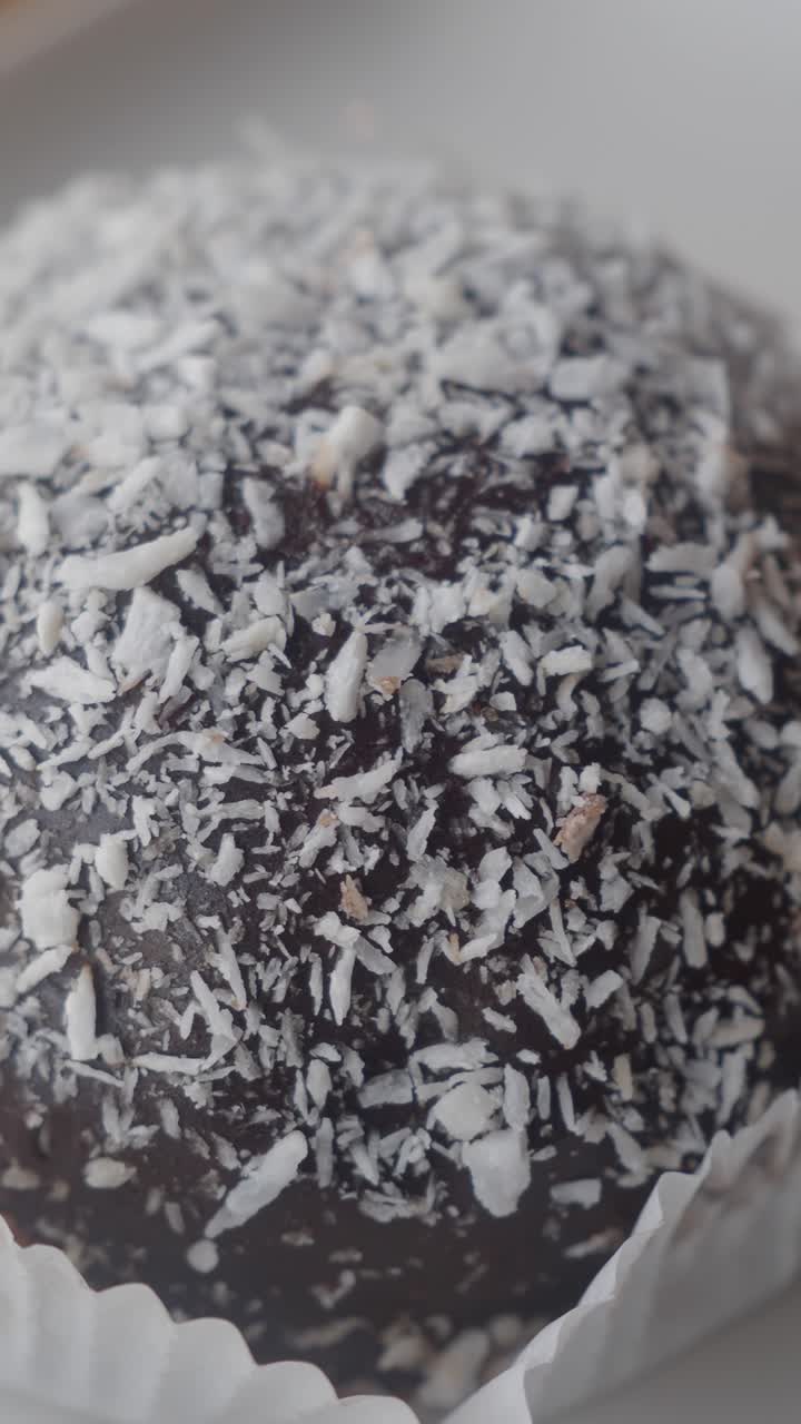 Primo piano di un tartufo al cioccolato ricoperto di cocco grattugiato.
