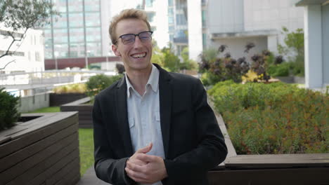 smiling man gesticulating, talking, making reportage outside