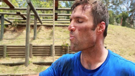 Hombre-En-Forma-Bebiendo-Agua-Después-Del-Entrenamiento-Durante-La-Carrera-De-Obstáculos