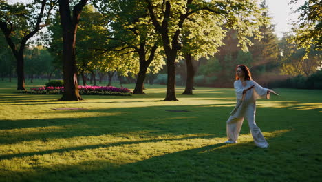 woman practicing tai chi in a park at sunrise
