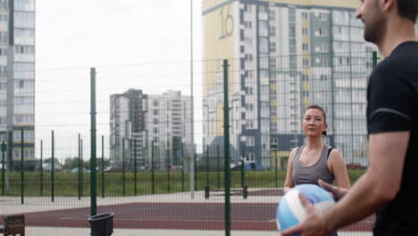 asian woman and arabic man hitting a volleyball