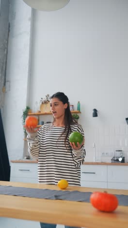 mujer jugando con frutas en la cocina