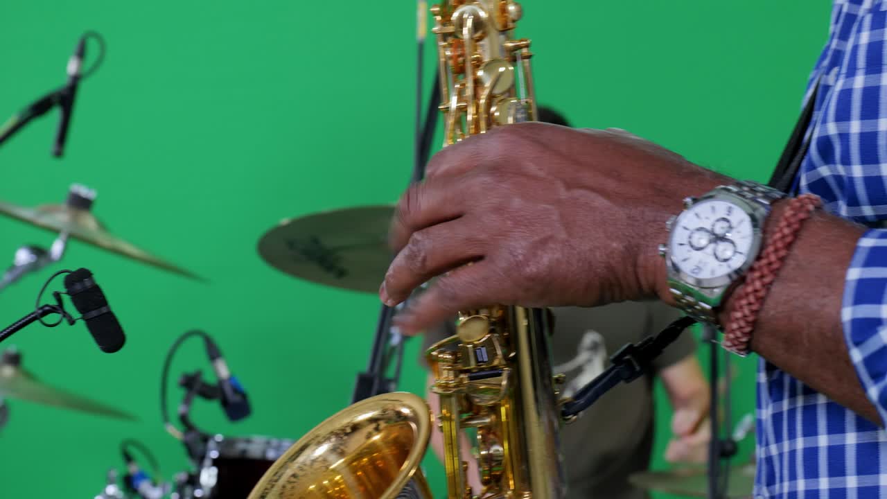 hands of a saxophonist playing on a tv chroma set
