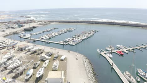 On-a-sunny-day,-drone-footage-tilts-and-approaches-a-dock-bustling-with-boats,-setting-the-scene-for-a-vacation-getaway