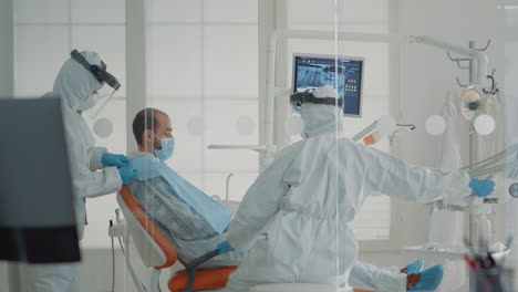 team of dentists and patient sitting in dental cabinet