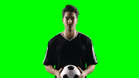 Football-player-holding-a-football-against-green-screen