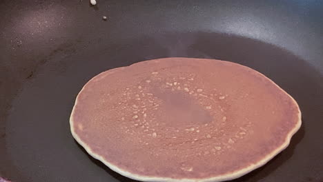 flipping a pancake. cooking breakfast for my baby