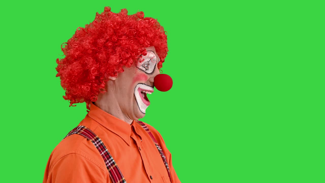 payaso usando una pantalla digital o virtual imaginaria en una pantalla verde, tecla de croma