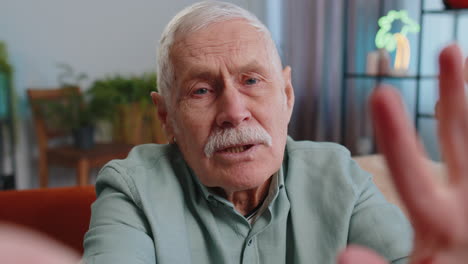 POV-of-elderly-grandfather-man-making-online-selfie-video-call-talking-waving-hand-looking-at-camera