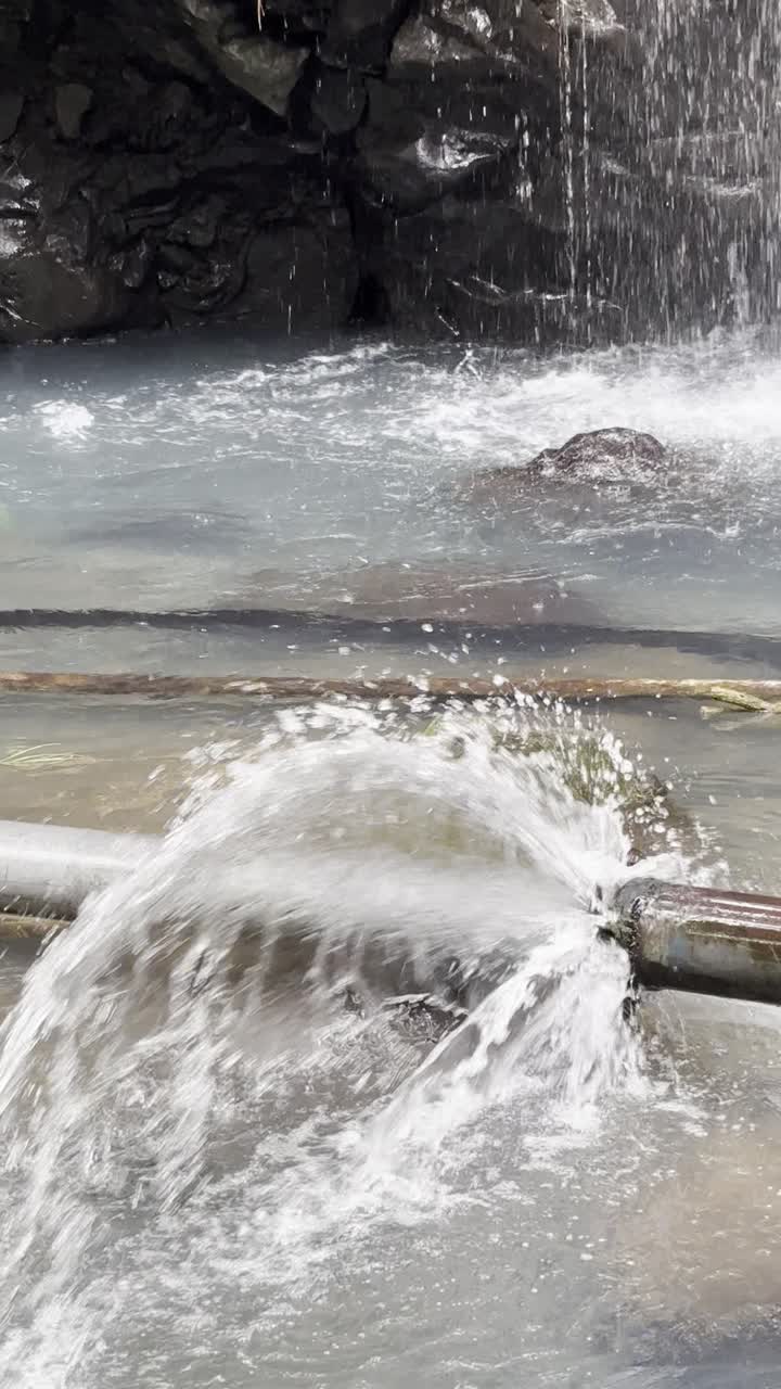Chorro de agua de una tubería reventada en un entorno natural