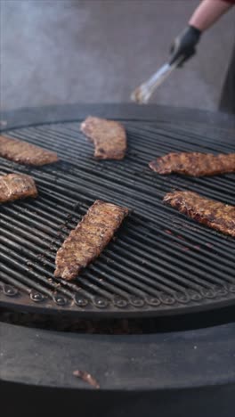 cocinar costillas en una gran parrilla al aire libre
