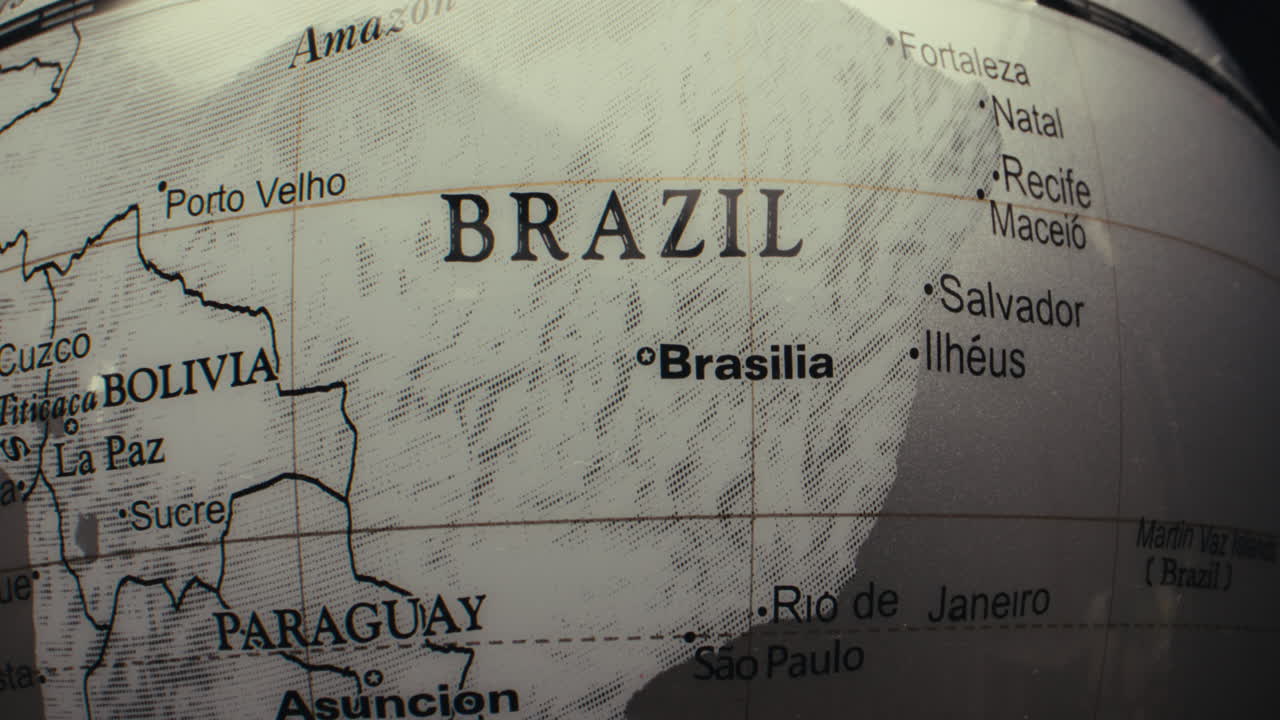 Close-up view of a world globe highlighting Brazil and surrounding countries.