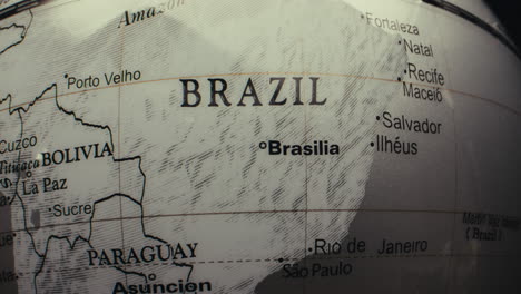 close-up view of a world globe highlighting brazil and surrounding countries.