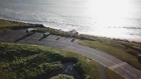 aerial push in: car park next to the ocean, ireland, connemara