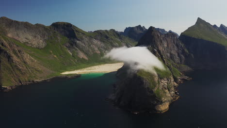 Toma-Cinematográfica-De-Un-Dron-De-La-Playa-De-Horseid-Con-Agua-Azul-Turquesa,-Nubes-Moviéndose-Sobre-Acantilados